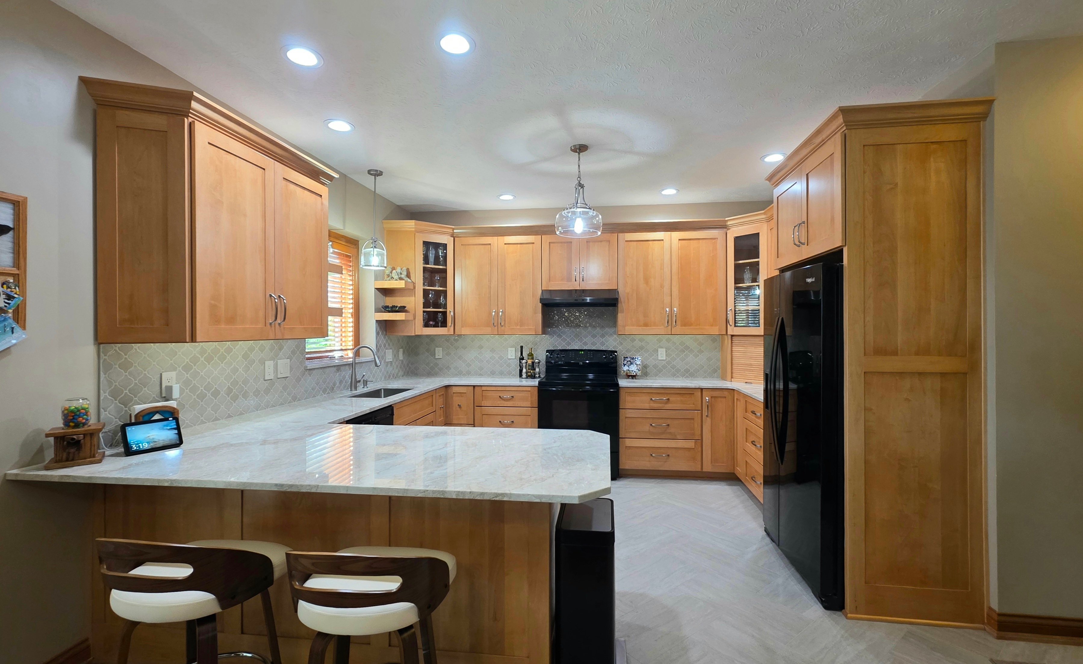 bright kitchen remodel with warm wooden cabinets and quarts countertops