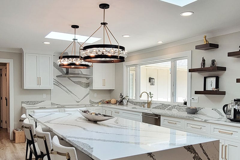 Kitchen island with waterfall marble countertop and large window