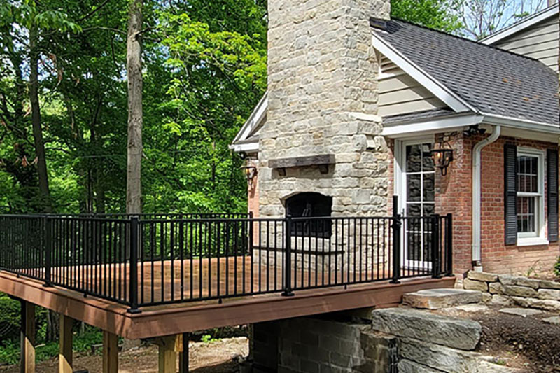 Decks & Patios featuring a wooden deck with black railing and exterior fireplace
